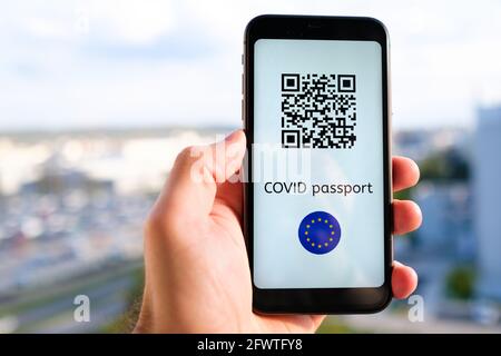 Covid Pass avec code QR avec drapeau de l'Union européenne sur l'écran dans smartphone dans la main de mans sur le fond de paysage urbain, mai 2021, San Francisco, Etats-Unis Banque D'Images