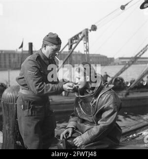 Sous la direction du capitaine J. Breman, la 2e entreprise d'ingénierie d'Amsterdam a commencé des travaux de récupération d'une portée très étendue. Sa tâche est d'éliminer tous les obstacles à la circulation dans la ville d'Amsterdam le plus rapidement possible, y compris les travaux de dédouanement dans le port. Le travail consiste également à dégager les barrages routiers créés par les Allemands, à combler les écarts dans la surface de la route causés par des blocs de bois, à extraire les caves inondées, etc. Obstructions de la circulation, soi-disant asperges, Qui a été érigé par des Allemands dans divers endroits d'Amsterdam et qui a posé un grave danger, surtout dans la soirée Banque D'Images