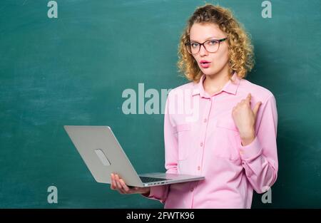 Étudiant en tige. Travail à distance. Carnet de notes de l'enseignant recherche des informations sur le fond du tableau de surveillance. Femme ordinateur portable surfer sur Internet. École en ligne. Enseignement en ligne Banque D'Images