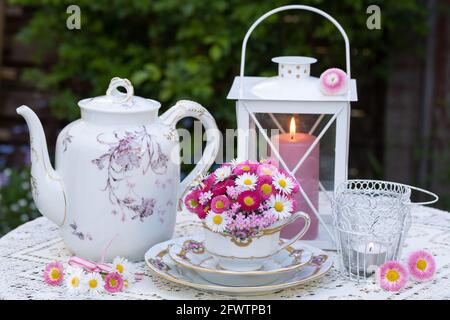 décoration romantique avec bouquet de fleurs et pâquerettes roses et porcelaine d'époque Banque D'Images