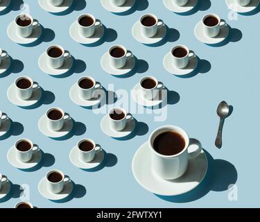 Motif rythmique des tasses avec café sur fond bleu. Banque D'Images