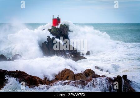 Structure rouge de balise sur North Rock enveloppée dans la mer Et vaporisez la base du mont Maunganui avec sauvage spectaculaire la mer de tempête s'est écrasant autour et au-dessus Banque D'Images