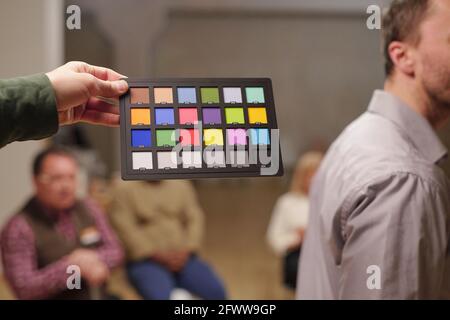 Palette de couleurs maintenue par l'homme contre les patients du psychologue assis sur les chaises Banque D'Images