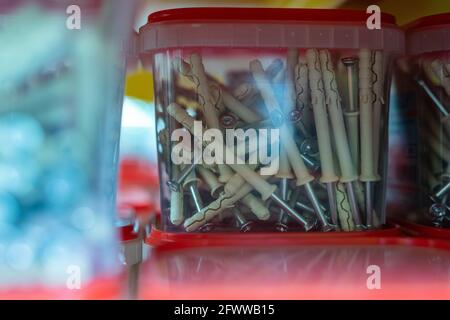 Groupe de contenants en plastique avec clous vendus dans le magasin de quincaillerie Banque D'Images