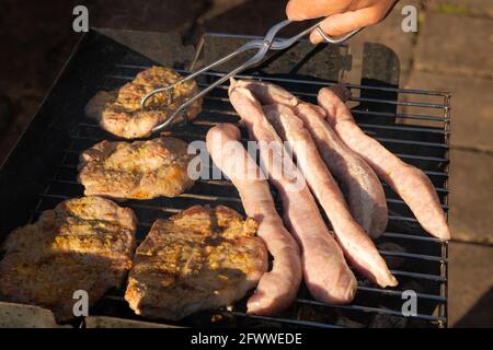 barbecue dans le jardin avec saucisses allemandes et steaks de porc Banque D'Images