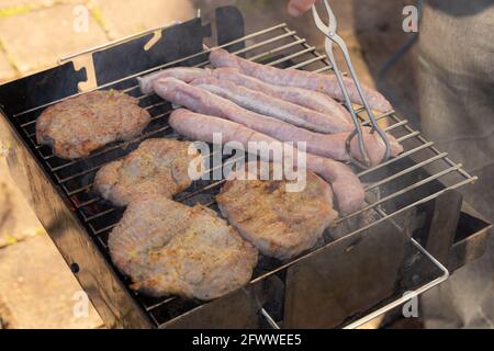 barbecue dans le jardin avec saucisses allemandes et steaks de porc Banque D'Images