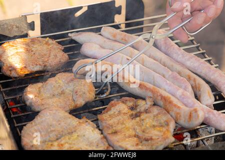 barbecue dans le jardin avec saucisses allemandes et steaks de porc Banque D'Images