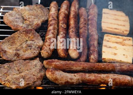 saucisses allemandes, steaks de porc et fromage grillé sur un grill Banque D'Images