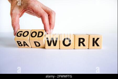 Symbole de bon ou mauvais travail. Homme d'affaires transforme des cubes en bois et change les mots « mauvais travail » en « bon travail ». Magnifique arrière-plan blanc, espace de copie. Entreprise Banque D'Images