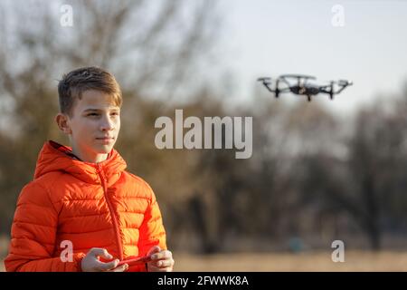 Un adolescent volant un petit drone dans le parc Banque D'Images