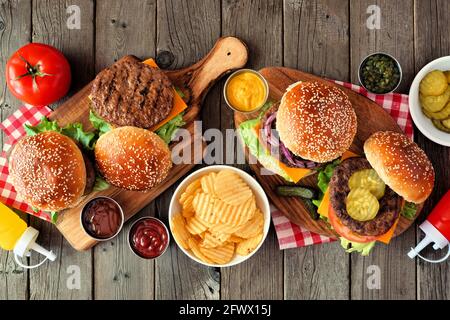 Scène de table de hamburger barbecue. Vue de dessus sur un arrière-plan en bois sombre. Banque D'Images