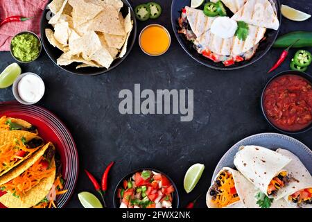 Cadre de cuisine mexicaine, au-dessus de la vue sur un fond d'ardoise sombre. Tacos, nachos, quesadilla et burritos. Copier l'espace. Banque D'Images