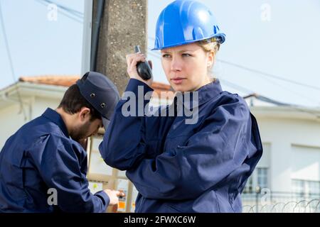 femme technicien lisant l'électricité à l'extérieur Banque D'Images