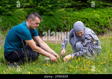 Un jeune couple musulman cueille des bleuets dans la forêt Banque D'Images