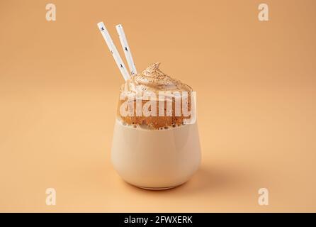 Dessert au café avec mousse fouettée sur fond orange. Café revigorant Dalgona. Banque D'Images