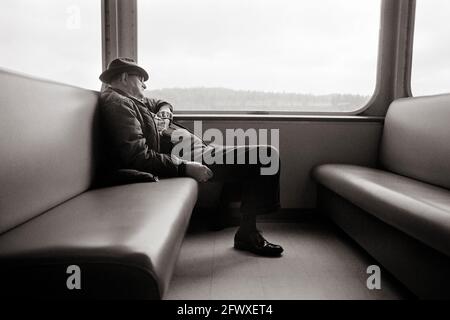 Personne âgée qui fait une sieste dans un ferry Banque D'Images