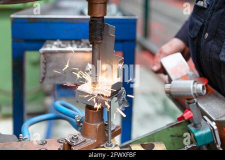 Gros plan d'un élément métallique soudé par points par un employé de l'usine. Concept de l'industrie. Photo de haute qualité Banque D'Images