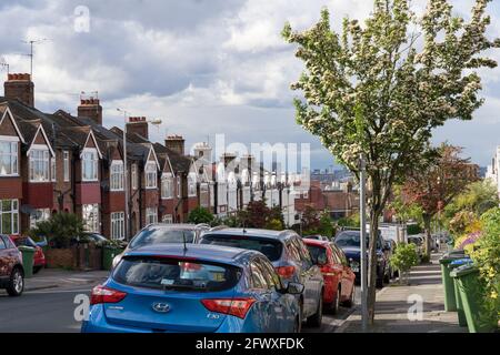 Parkings sur le côté de la route le long de la rangée de maisons en terrasse dans le sud de Londres, greenwich, ciel couvert, Angleterre, Royaume-Uni Banque D'Images