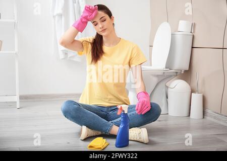 Une jeune femme se reposant après avoir nettoyé sa salle de bains Banque D'Images