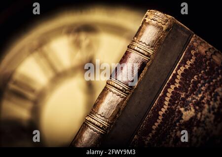 livre en cuir antique avec cadran d'horloge en arrière-plan. Banque D'Images