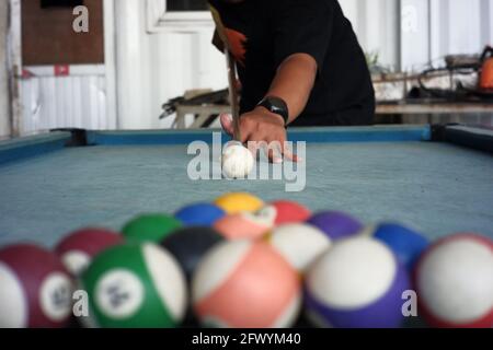 les mains des hommes jouant au billard sur une table bleue recouverte de moquette. portrait d'un joueur professionnel avec un premier plan de billard flou. la première étape de Banque D'Images