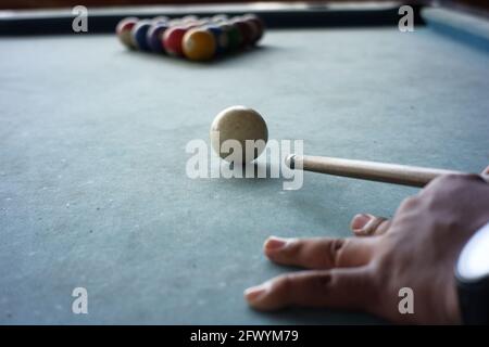 gros plan de la main du joueur de piscine se préparant à commencer le jeu. Le premier mouvement de jouer au billard détruit la formation de quinze boules de billard qui Banque D'Images