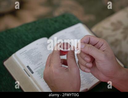 Homme tenant du pain et du vin dans la communion ou l'Eucharistie de Hoy, commémorant la Cène. Banque D'Images