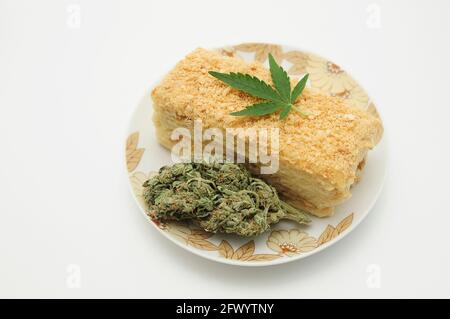 Gâteau de bouffée avec de l'huile de CBD et des fleurs de cannabis isolées sur fond blanc. Cuisine équipée de marijuana. Banque D'Images