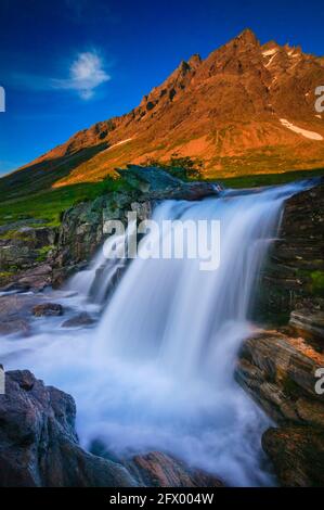 Belle cascade et la lumière du soleil dernière soirée sur la montagne magasin Venjetind à Venjedalen, Rauma kommune, Møre og Romsdal, Norvège, Scandinavie. Banque D'Images