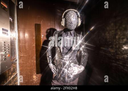 Scintillez l'homme masqué dansant dans un ascenseur Banque D'Images