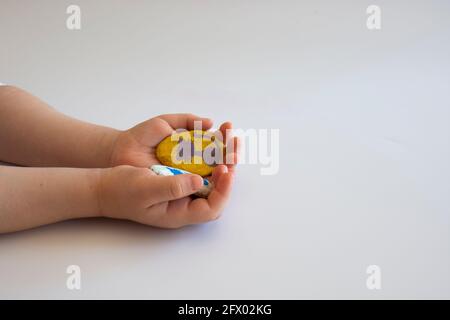 la petite fille montre à son père les pierres qu'elle a peint en couleur Banque D'Images