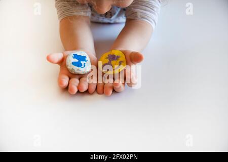 la petite fille montre à son père les pierres qu'elle a peint en couleur Banque D'Images