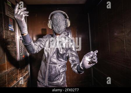 Scintillez l'homme masqué dansant dans un ascenseur Banque D'Images