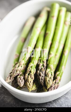 Asperges fraîches dans un plat de cuisson en céramique blanche. Banque D'Images