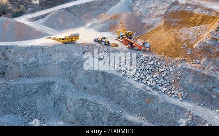 Pelles hydrauliques, bulldozer et convoyeurs sur le dessus de la carrière de pierres, vue aérienne Banque D'Images