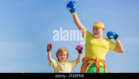 Petit sportif de garçon à l'entraînement de boxe avec entraîneur. Sportif entraîneur de boxe petit garçon dans des gants de boxe rouges. Petit garçon faisant de l'exercice de boxe avec Banque D'Images