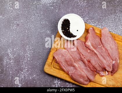 Côtelette de jambe brute de la jambe de porc sur une planche de bois sur un fond en bois foncé. Vue de dessus, plan d'appartement Banque D'Images