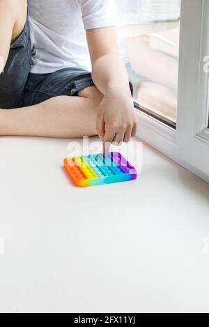Pop-it. Le garçon joue un jouet tendance pour enfants. Banque D'Images