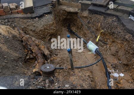 Dug up trottoir révélant les fils dans des tubes de protection. Construction de lignes électriques ou de câbles de télécommunication, construction de connexio réseau optique Banque D'Images