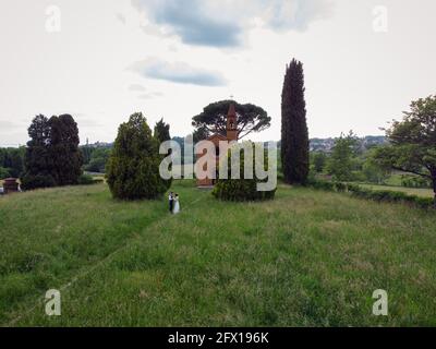 Vue de drone de couple fraîchement marié à l'église rouge de Pomelasca situé dans la campagne Lombardie, Inverigo, province de Côme, Brianza, Italie, E Banque D'Images