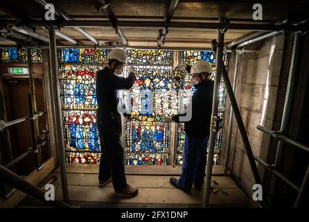 Le conservateur Matthew Nickels (à gauche) et le Maître Glazier Tony Cattle (à droite) de York Glaziers Trust ont enlevé un panneau de vitraux au début d'un nouveau projet de cinq ans, de 5 millions de livres sterling, pour conserver le transept sud-est de York Minster et sa fenêtre médiévale de St Cuthbert. Date de la photo: Mardi 25 mai 2021. York Glaziers Trust entreprend des travaux pour retirer les vitraux de la fenêtre, qui a près de 600 ans et qui est l'une des plus grandes fenêtres narratives encore en place dans le monde. Le projet comprend des travaux importants de conservation et de restauration des vitraux et des éléments en pierre o Banque D'Images