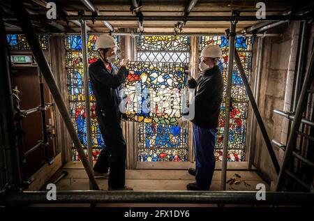 Le conservateur Matthew Nickels (à gauche) et le Maître Glazier Tony Cattle (à droite) de York Glaziers Trust ont enlevé un panneau de vitraux au début d'un nouveau projet de cinq ans, de 5 millions de livres sterling, pour conserver le transept sud-est de York Minster et sa fenêtre médiévale de St Cuthbert. Date de la photo: Mardi 25 mai 2021. York Glaziers Trust entreprend des travaux pour retirer les vitraux de la fenêtre, qui a près de 600 ans et qui est l'une des plus grandes fenêtres narratives encore en place dans le monde. Le projet comprend des travaux importants de conservation et de restauration des vitraux et des éléments en pierre o Banque D'Images