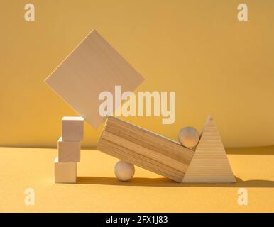 Figures en bois équilibrées sur fond jaune Banque D'Images
