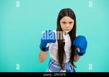 boxeur d'enfants concentré qui frappe dans des gants de boxe pendant l'entraînement sportif, l'espace de copie, la détermination Banque D'Images