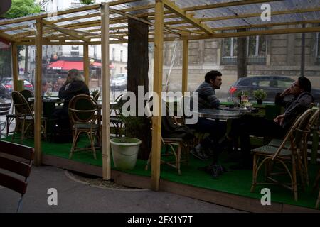 Les Parisiens peuvent s'asseoir sur une terrasse temporaire de café, construite pour permettre aux clients de boire dehors après que les restrictions Covid-19 ont été levées à Paris en mai 2021 - le Montmartre café, rue Custine, 75018, Paris, France Banque D'Images