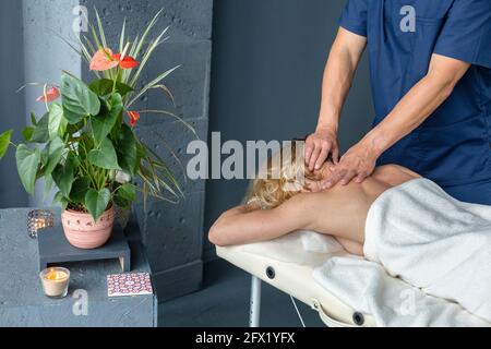 Jeune belle femme ayant un massage dans le salon de spa. Relaxation et soin sur le dos de la femme Banque D'Images