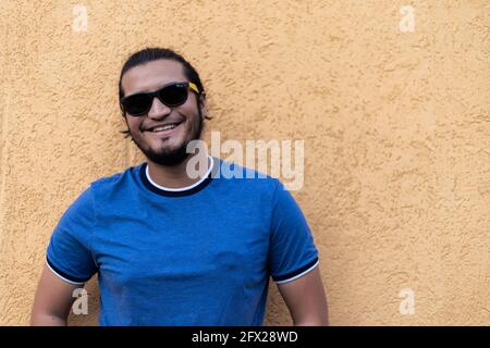 jeune latino homme avec des lunettes de soleil souriant regardant l'appareil photo. Tir horizontal Banque D'Images
