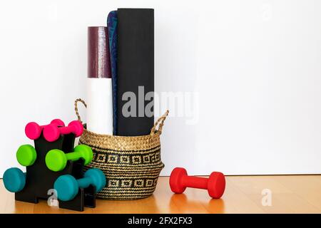 Différentes compositions d'haltères et de tapis de fitness sur le fond du sol. Accessoires de sport pour le fitness à la maison. Salle de gym à la maison, bien-être Banque D'Images