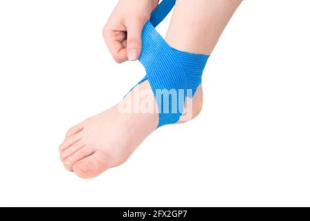 Bandage élastique bleu de la cheville, fond blanc, isoler. Le concept de fixation d'un joint douloureux sur la jambe Banque D'Images
