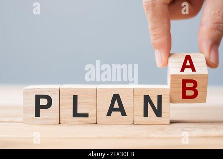 Homme d'affaires flipping blocs de cube en bois avec PLAN UN changement à PLAN B texte sur fond de table. Stratégie, leadership, gestion, marketing, proje Banque D'Images